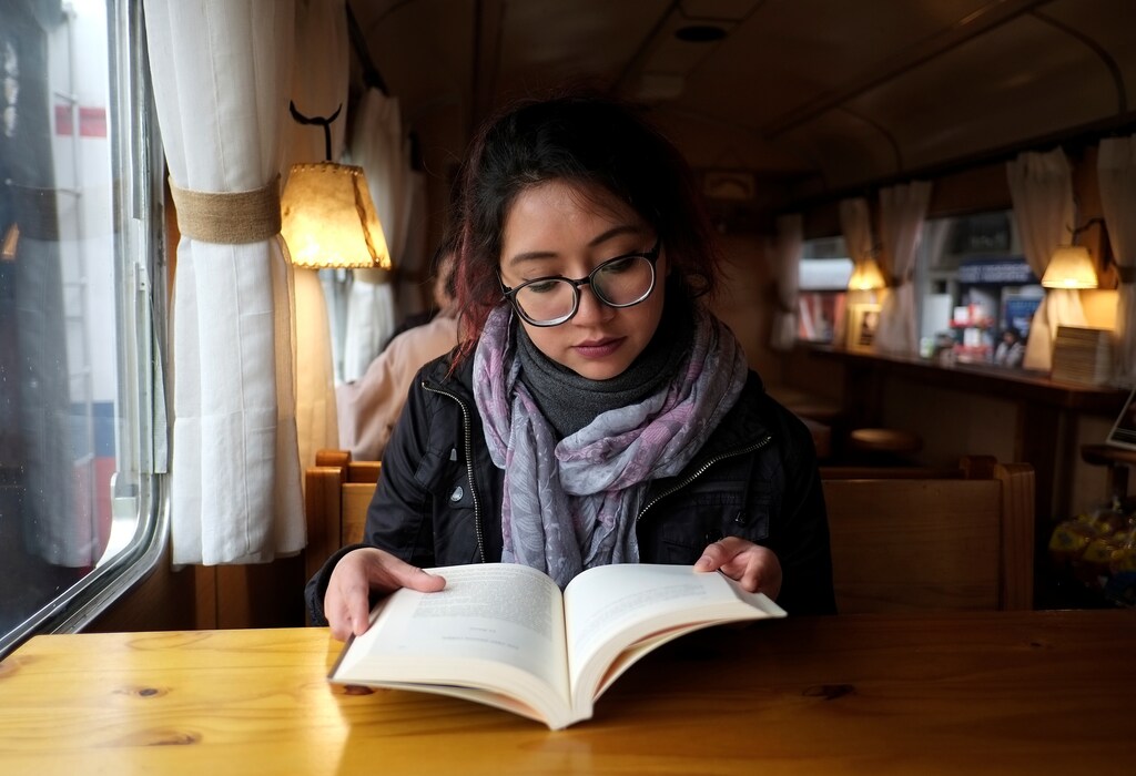 A woman reads a book in old train wagon converted into a café and shop in La Paz, Bolivia.