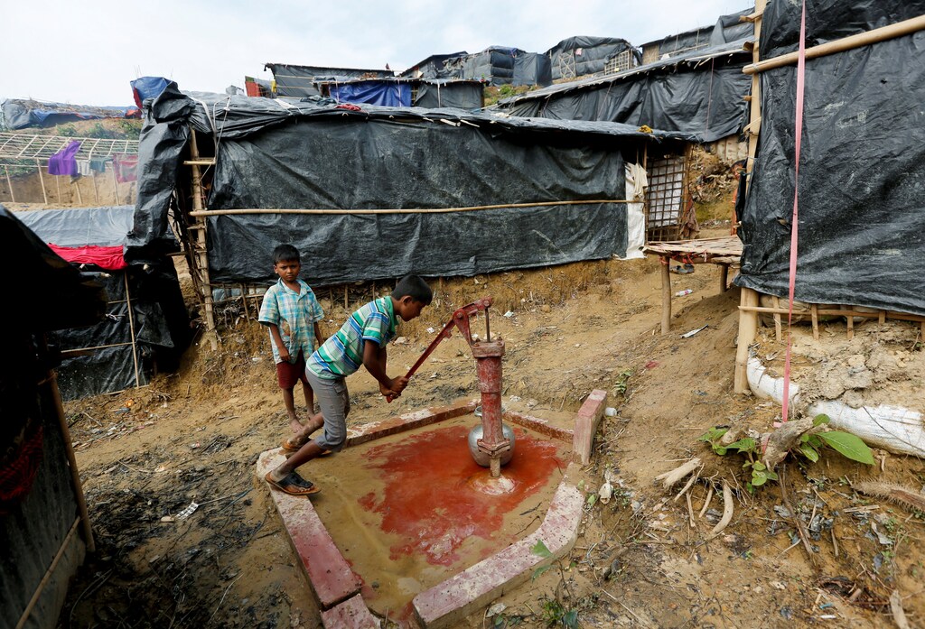 Rohingya refugee Abdul Hafes, 10, brother of Nur Hafes, fills a container with drinking water from a hand pump near his shelter at Palong Khali refugee camp, near Cox's Bazar, Bangladesh, November 1, 2017. Twelve-year-old Nur is sole breadwinner for seven younger siblings and his mother. REUTERS/Adnan Abidi SEARCH "BREADWINNER REFUGEE" FOR THIS STORY. SEARCH "WIDER IMAGE" FOR ALL STORIES. - RC19AB4E5C30