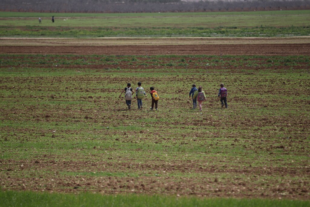 Students walk as they carry their bags after leaving the Freedom School, in the town of al-Tamanah, in the southern countryside of Idlib, Syria, March 9, 2016. This school was converted from a poultry farm by the residents of the town more than a year ago. REUTERS/Khalil Ashawi - GF10000339538