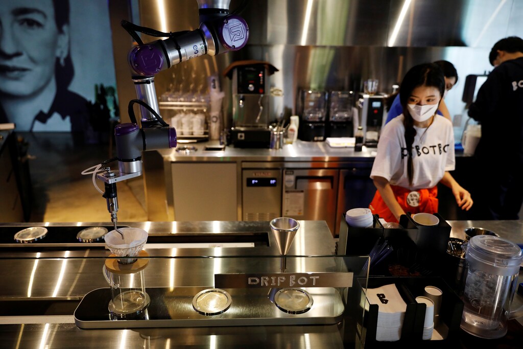 Drip Bot makes a cup of coffee as an employee wearing a mask to avoid the spread of the coronavirus disease (COVID-19) works at a cafe in Seoul, South Korea, June 3, 2020. Picture taken on June 3, 2020. REUTERS/Kim Hong-Ji - RC222H9JS34E