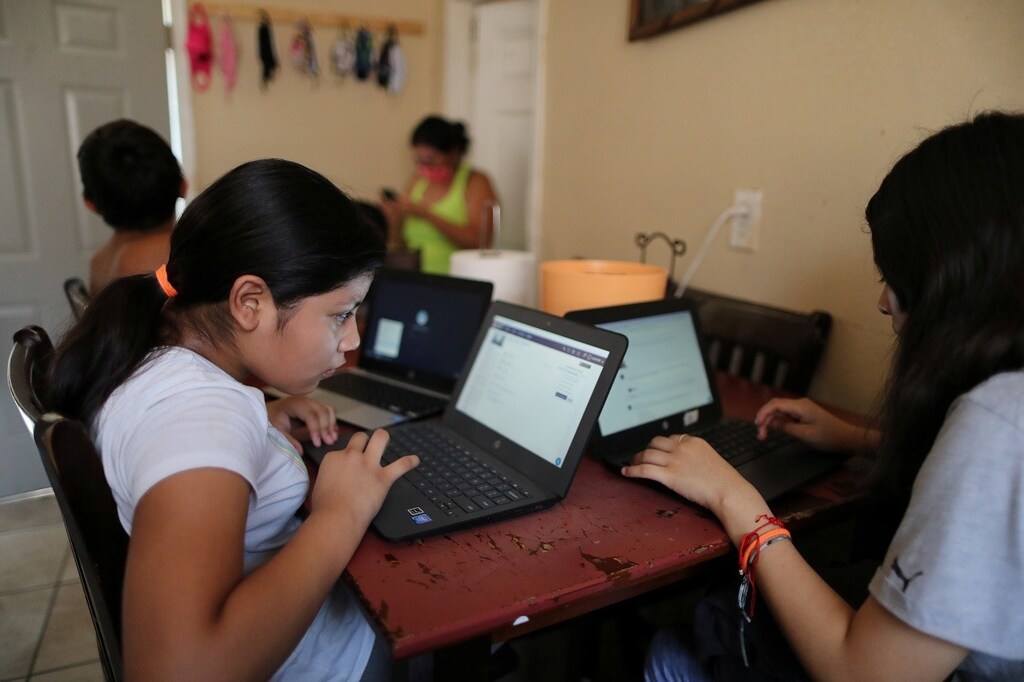 Los Angeles Unified School District (LAUSD) student Andrea Ramos, 10, works on a school-issued computer with unreliable internet connectivity along with her siblings, during the global outbreak of the coronavirus disease (COVID-19), at their family home in Los Angeles, California, U.S., August 18, 2020. REUTERS/Lucy Nicholson - RC2LGI98G2MH