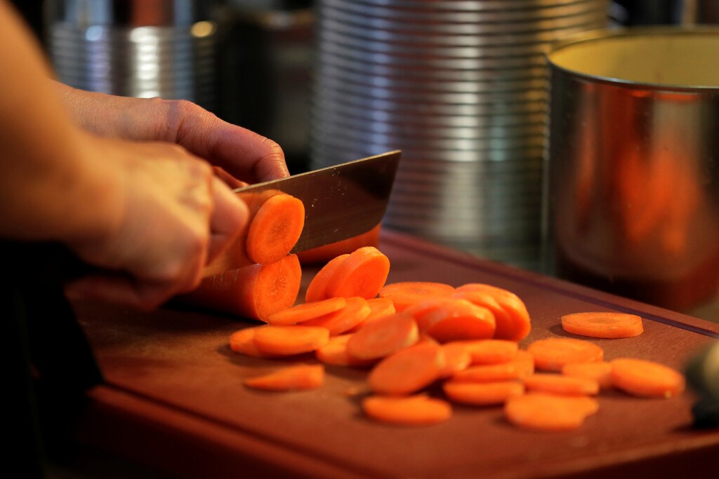 An employee cuts carrots at Maran Vegan, Austria's first strictly vegan supermarket, in Vienna Austria January 31, 2018. REUTERS/Heinz-Peter Bader - RC14FDC1A050