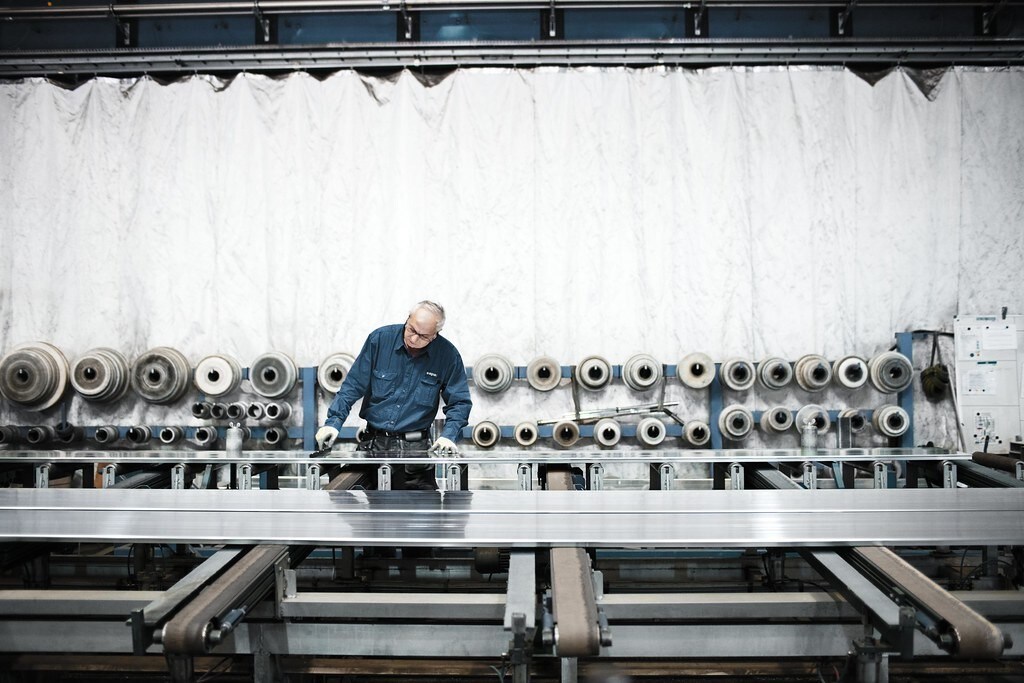 Man in blue shirt works at aluminium processing plant: Decarbonization technology could reduce carbon emissions from aluminium processing by 65% over the next 40 years.