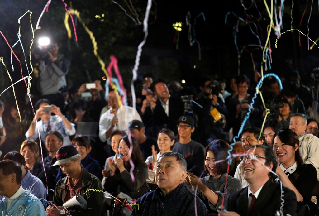 Fans of the Japanese writer Haruki Murakami celebrate after they heard that Japanese-born Kazuo Ishiguro won the Nobel Prize for Literature while they gather in a shrine with the hope of celebrating Murakami's winning in the prize in Tokyo, Japan, October 5, 2017. REUTERS/Kim Kyung-Hoon - RC1FAD98AA70