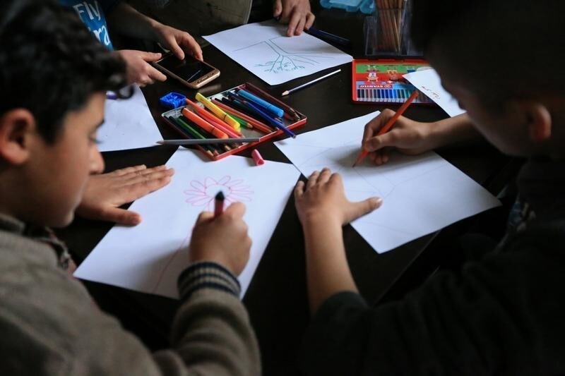 Yazidi students draw at the psychotherapy centre in the Rawanga camp, in Duhok, Iraq February 25, 2018. Picture taken February 25, 2018.