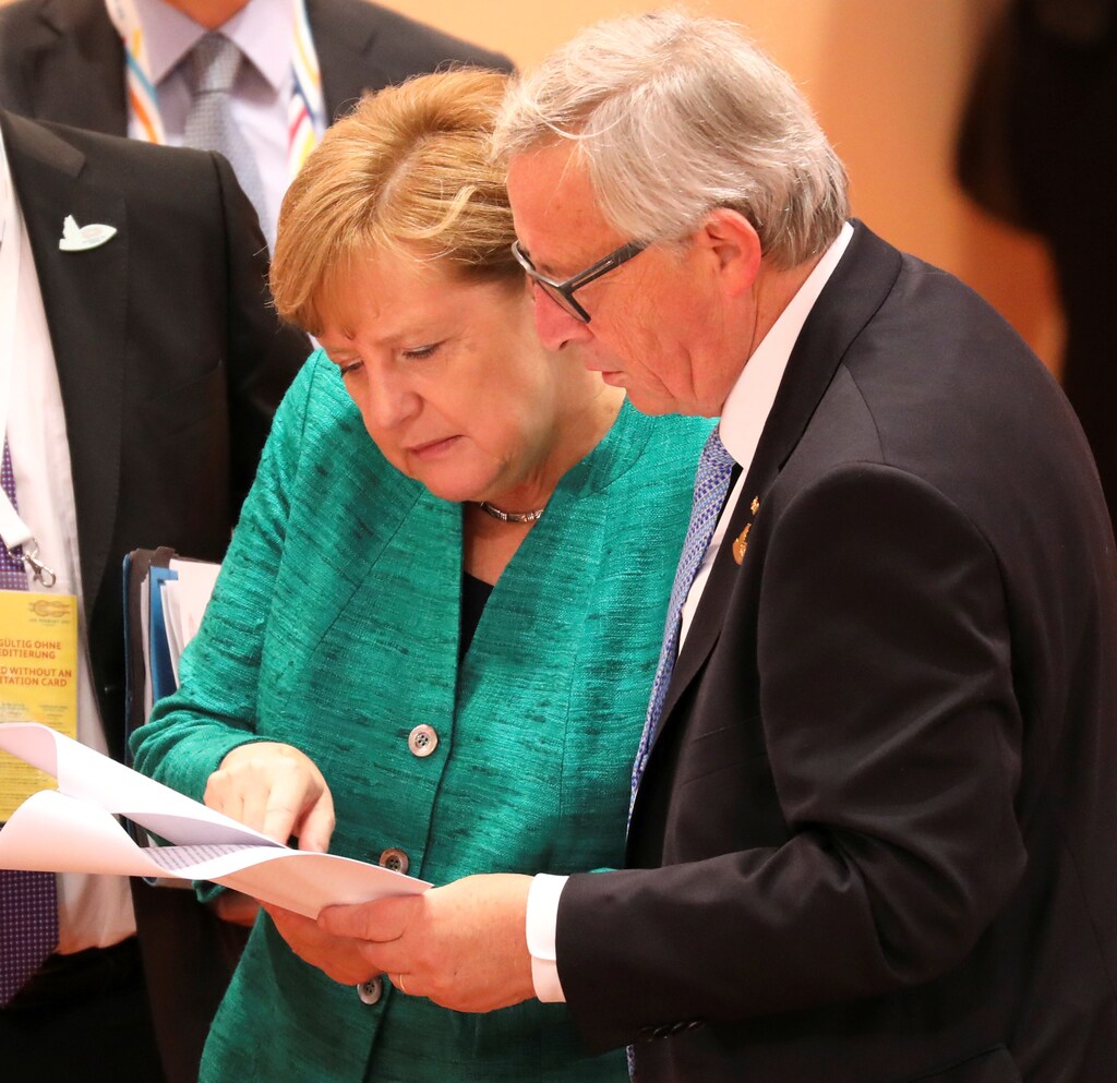German Chancellor Angela Merkel and the President of the European Commission Jean-Claude Juncker look through documents prior the beginning of the third working session of the G20 meeting in Hamburg, Germany, July 8, 2017. REUTERS/Ludovic Marin/POOL - RC1E4EFD92F0