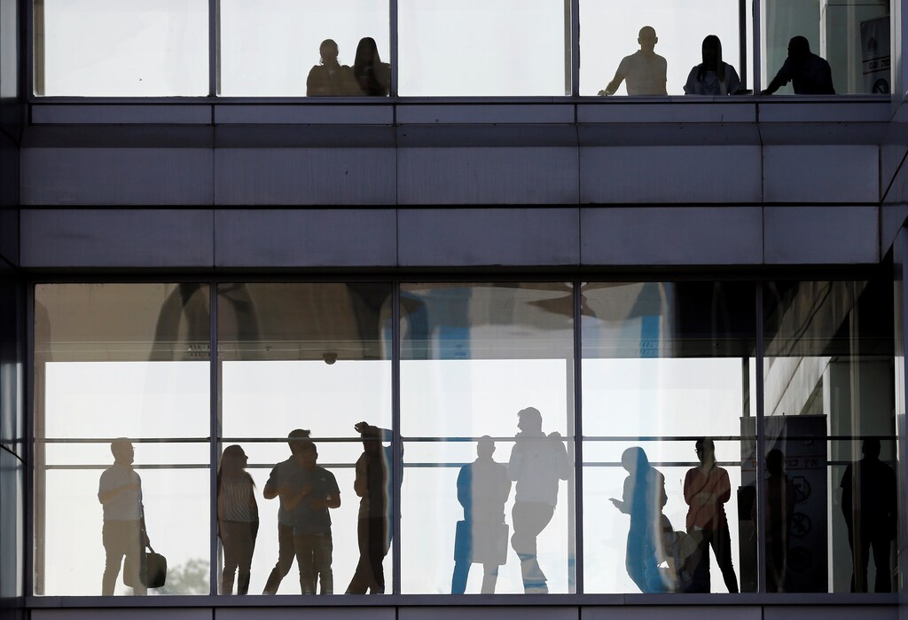 People are silhouetted as they stand in a building overlooking an honor guard ceremony held for General Joseph Dunford, the Chairman of the U.S. Joint Chiefs of Staff, in Tel Aviv, Israel May 9, 2017. REUTERS/Nir Elias - RTS15RVN