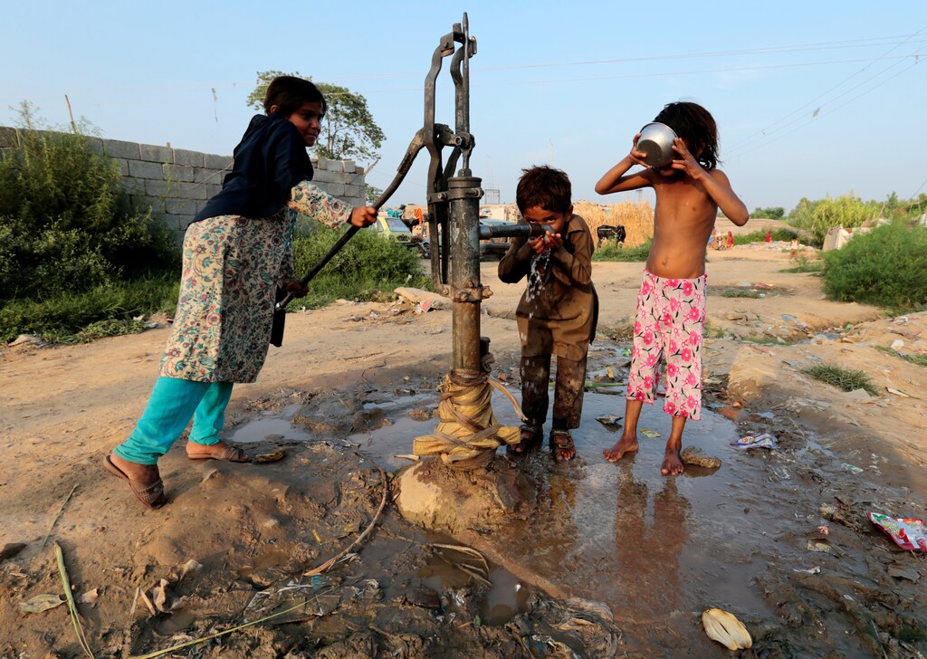 Children drink water from a hand pump in a slum in Islamabad, Pakistan July 19, 2017. REUTERS/Caren Firouz - RC1EDD666F70