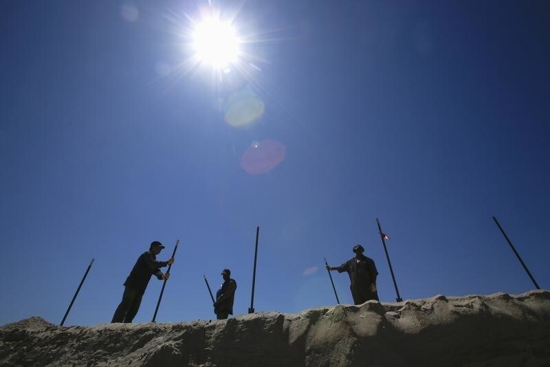 Workers install a fence at the end of the first full section of the newly constructed Rockaway Boardwalk after it was damaged by Hurricane Sandy as people celebrate the opening of the beach season in New York May 23, 2015.