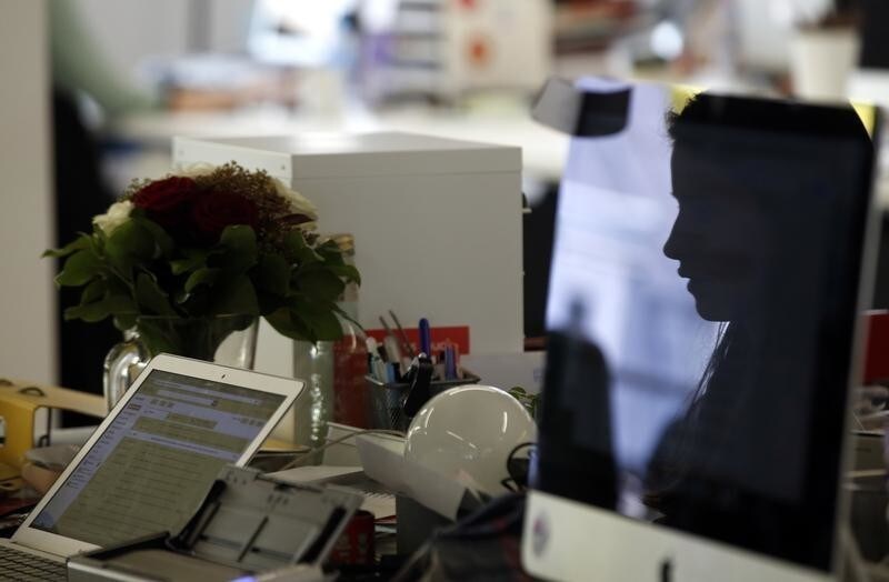 An employee of peer-to-peer car rental company Drivy is reflected in the screen of her computer as she works in their Paris headquarter, April 7, 2016. REUTERS/Philippe Wojazer - D1AESXAATOAA
