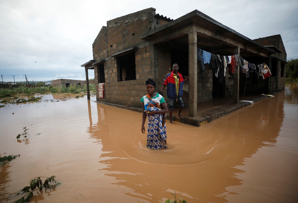 Villagers wade through floodwaters outside their home, flooded in the aftermath of Cyclone Kenneth, at Wimbe village in Pemba, Mozambique.