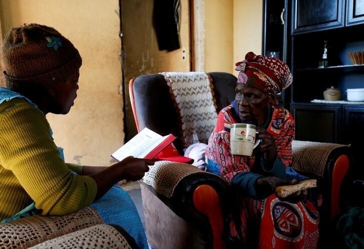 Fikhile Mthiyane reads the bible with her mother-in-law Thumekile Mthiyane, 90, who is known as Gogo Mthiyane, at their family home in KwaNdengezi, South Africa, May 18, 2017. Gogo means grandmother in Zulu. REUTERS/Rogan Ward SEARCH "WARD GENERATIONS" FOR THIS STORY. SEARCH "WIDER IMAGE" FOR ALL STORIES.