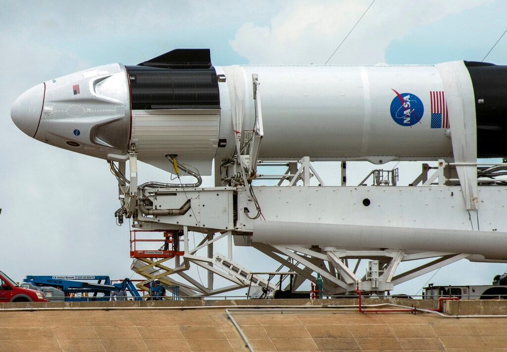 Crews work on the SpaceX Crew Dragon, attached to a Falcon 9 booster rocket, as it sits horizontal on Pad39A at the Kennedy Space Center in Cape Canaveral, Florida, U.S. May 26, 2020. REUTERS/Steve Nesius - RC2JWG9XXHY6