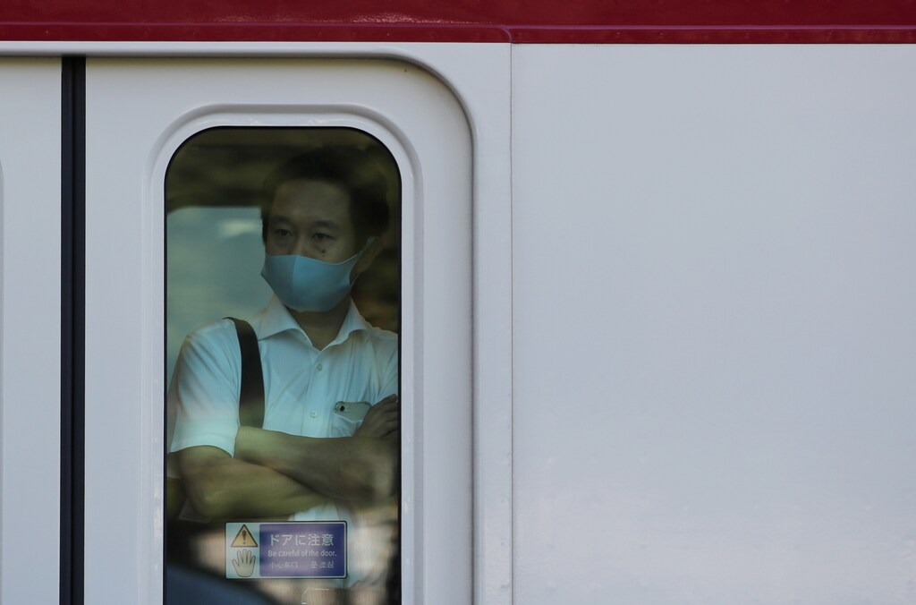 A man wearing a protective mask rides a train, amid the coronavirus disease (COVID-19) outbreak, in Tokyo, Japan, August 10, 2021. REUTERS/Kim Kyung-Hoon - RC2Z1P9IZ464