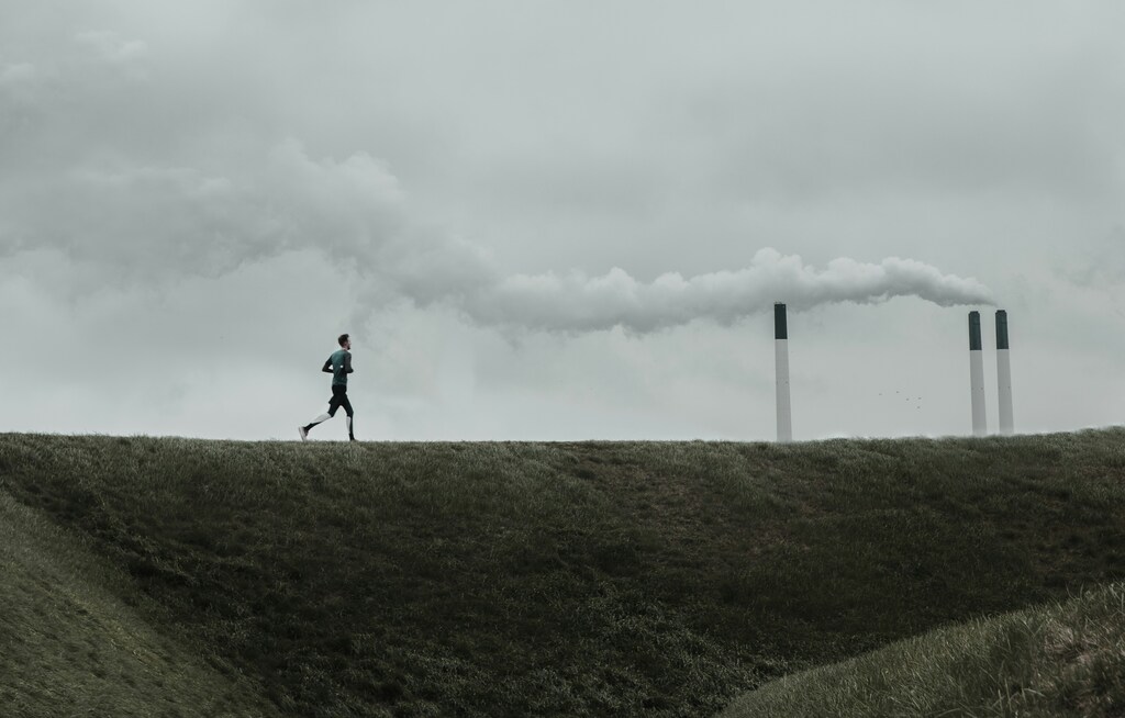 A man running in front of three smoke stacks: Europe’s climate policy must think about carbon markets more holistically