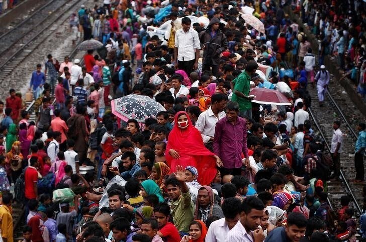 People sit atop an overcrowded passenger train as they travel home to celebrate Eid al-Fitr festival, which marks the end of the Muslim holy fasting month of Ramadan, at a railway station in Dhaka, Bangladesh, July 5, 2016. REUTERS/Adnan Abidi