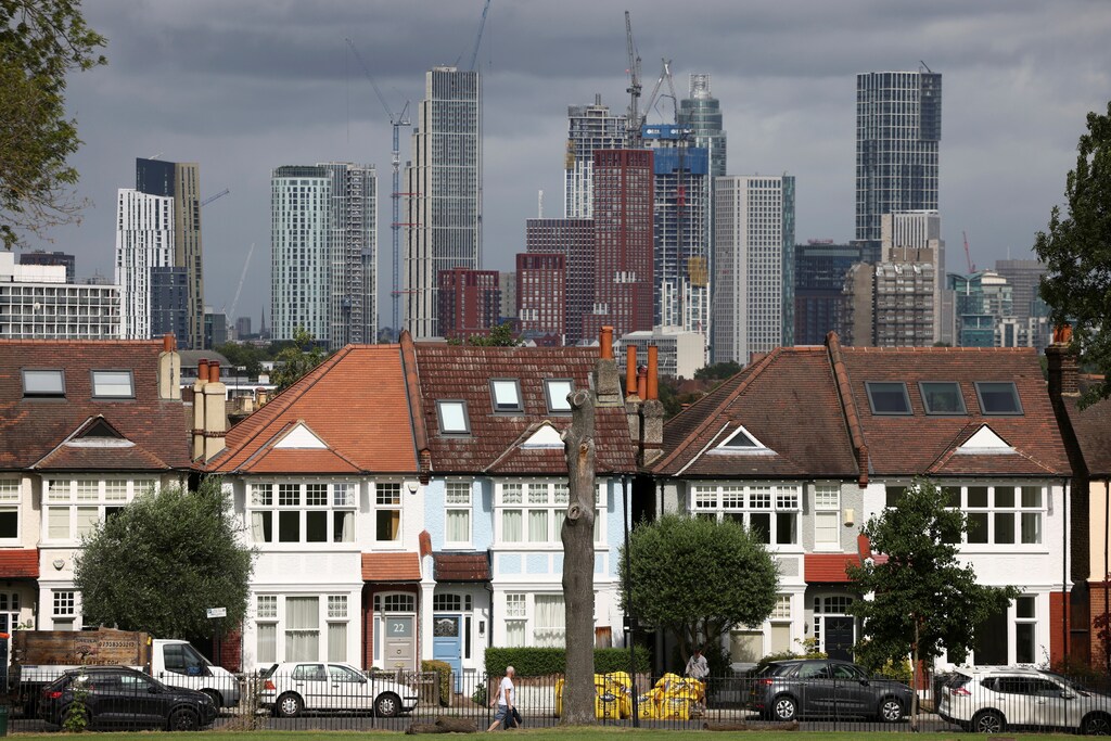 High-rise apartments under construction can be seen in the distance behind a row of residential housing in south London, Britain, August 6, 2021. REUTERS/Henry Nicholls - RC2MZO96C6E3