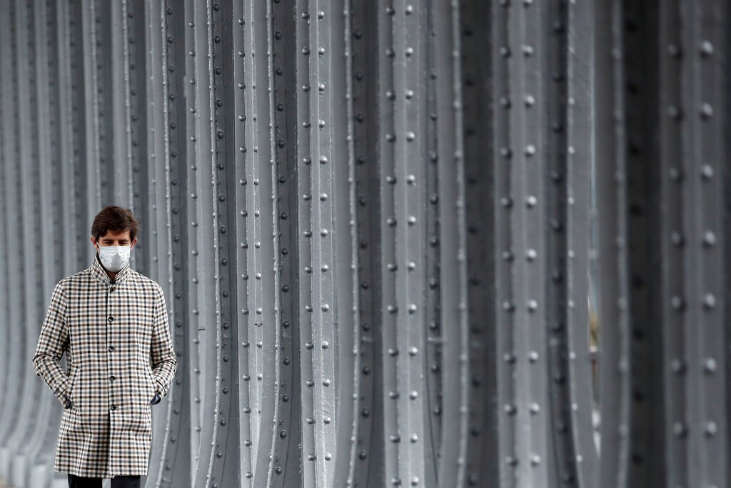 A man, wearing a protective face mask, walks on the Pont de Bir-Hakeim Bridge in Paris amid the coronavirus disease (COVID-19) outbreak in France, February 18, 2021. REUTERS/Gonzalo Fuentes TPX IMAGES OF THE DAY - RC22VL9ZHI6M