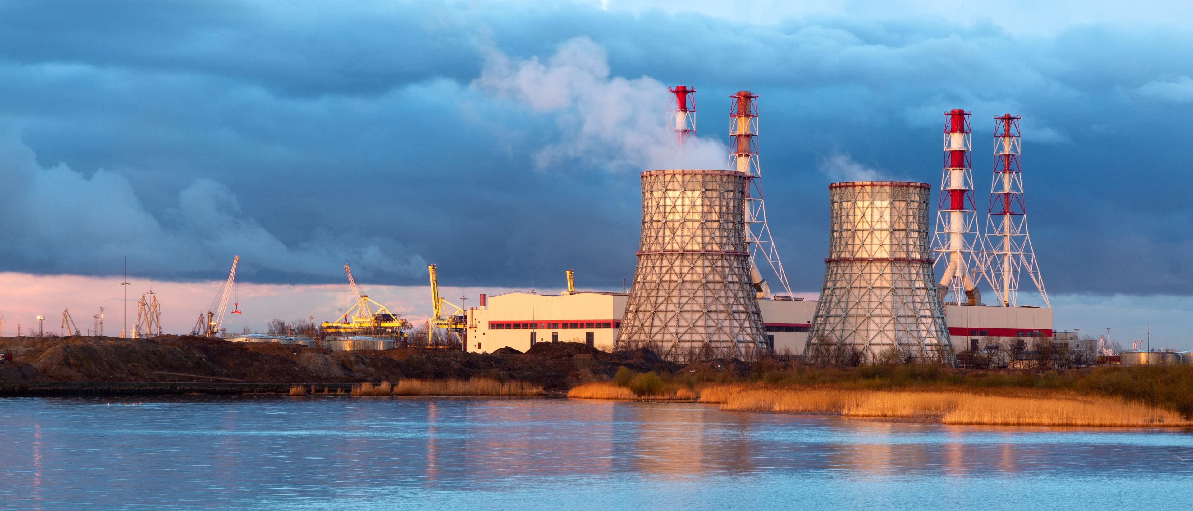 Defining 'systemically important critical infrastructure' is vital to keep services running in the event of a cyberattack. Pictured: Cooling towers of a power station seen beyond water 