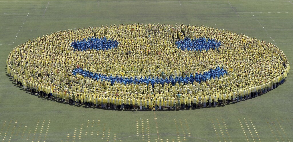 Students stand in formation on a field as they form a smiley face in an attempt to break a world record in celebration of the 110th anniversary of their university in Nanjing, Jiangsu province April 27, 2012. A total of 3,110 students from Nanjing Agricultural University broke the Guinness World Record for World Largest Smiley Face on Friday, overtaking the last world record of 2,961 volunteers in Canada on July 2011, local media reported. REUTERS/Sean Yong (CHINA - Tags: EDUCATION SOCIETY TPX IMAGES OF THE DAY) - GM1E84R17F001