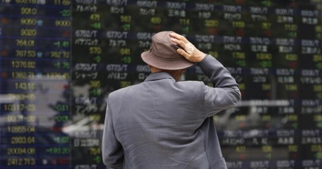 Image: A man looks at a stock quotation board outside a brokerage in Tokyo May 11, 2012. REUTERS/Toru Hanai
