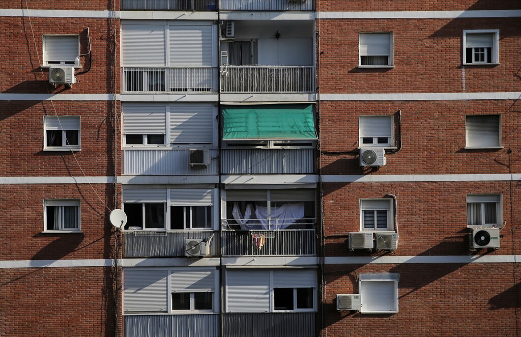 A view shows window air conditioning condenser units hanging on block of flats during a week-long heatwave in Madrid, Spain, July 22, 2022. REUTERS/Isabel Infantes