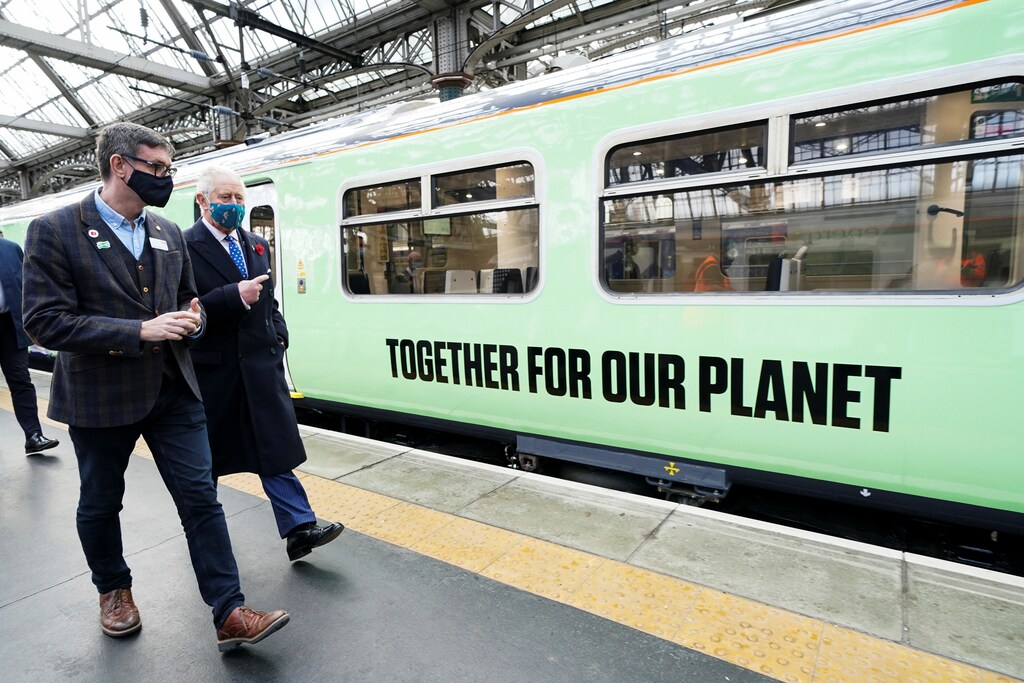 Britain's Prince Charles walks next to a train powered by green hydrogen