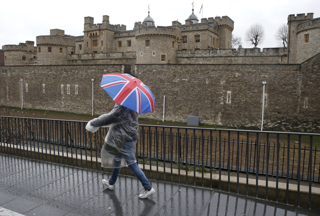 A tourist carrying a Union Flag umbrella walks in the rain during a spell of wet weather, next to The Tower of London, in London, Britain January 15, 2017. Britain's Prime Minister Theresa May will call on Britons to reject the acrimony of the Brexit referendum in a speech this week that some newspapers have billed as setting the stage for a "hard" exit from the European Union.Investors will scrutinise May's speech on Tuesday for clues on whether she plans to prioritise immigration controls and bilateral trade deals in a "hard Brexit" that would see Britain leave the EU's single market and customs union. REUTERS/Peter Nicholls - RTSVM6Q