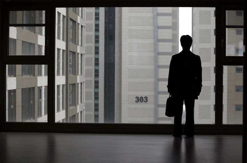 Kim Keon-hoon, a worker with Byucksan Engineering & Construction, looks out through the window from his empty two-bathroom, four-bedroom apartment before an interview with Reuters, in the middle class suburb in Goyang, north of Seoul April 1, 2013. Kim says he was forced to buy an unsold 800 million won ($716,400) apartment, built by his employer in 2008, as the company teetered on the edge of bankruptcy. Five years after the global financial crisis, South Korean construction workers are feeling the pinch more than ever as they shoulder a mountain of debt from a real estate bust that has cast a long shadow on the country's growth prospects. Picture taken April 1, 2013. REUTERS/Lee Jae-Won (SOUTH KOREA - Tags: BUSINESS REAL ESTATE) - RTX105GC