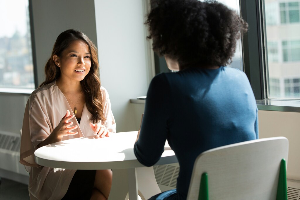 Two women sitting across from each other at a table: Inclusion and equal opportunities at work can help businesses face global challenges.