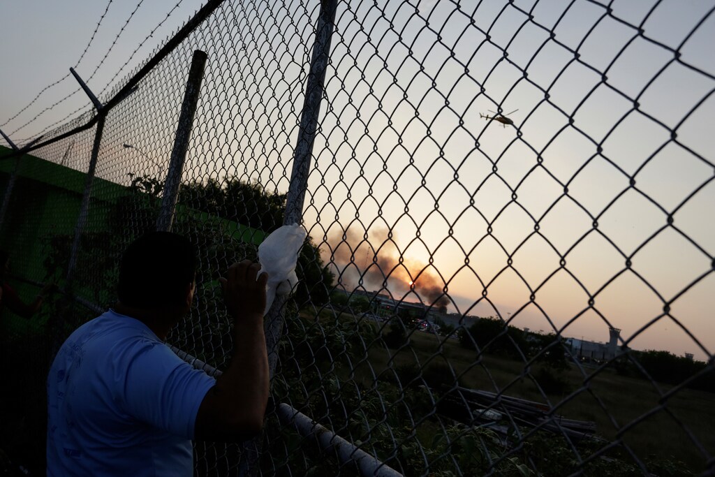 The relative of an inmate looks at a police helicopter flying over the Cadereyta prison after a riot broke out at the prison, in Cadereyta, on the outskirts of Monterrey, Mexico March 27, 2017. REUTERS/Daniel Becerril TPX IMAGES OF THE DAY - RTX32ZDW
