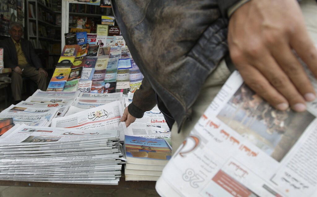 A resident buys newspapers from a kiosk in Baghdad February 23, 2009. A boom in local media since the U.S.-led invasion in 2003 has given Iraqis a choice between some 200 print outlets, 60 radio stations and 30 TV channels in Arabic, Turkmen, Syriac and two Kurdish dialects. Yet most media outlets remain dominated by sectarian and party patrons who use them for their own ends, and have yet to become commercially sustainable enterprises let alone watchdogs keeping government under scrutiny, the favoured Western model. Picture taken February 23, 2009. To match feature IRAQ/JOURNALISM REUTERS/Mohammed Ameen (IRAQ CONFLICT SOCIETY MEDIA POLITICS) - RTXCM09