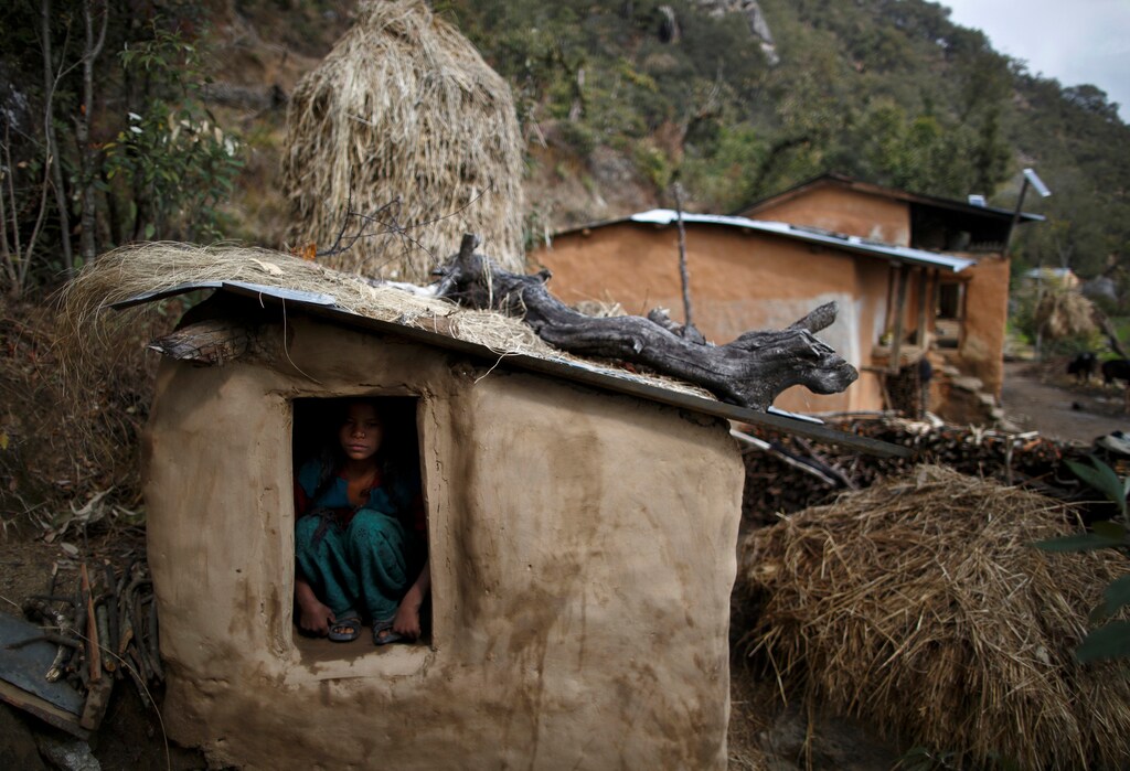 Uttara Saud, 14, sits inside a Chaupadi shed in the hills of Legudsen village in Achham District in western Nepal, February 16, 2014. Chaupadi is a tradition observed in parts of Nepal, which cuts women off from the rest of society when they are menstruating. Women who practice traditional chaupadi have to sleep in sheds or outbuildings while they are on their period. Chaupadi was banned by Nepal's Supreme Court in 2005, but it is still common in the country's far and mid-western regions. Picture taken February 16, 2014. REUTERS/Navesh Chitrakar/File Photo. SEARCH "POY DECADE" FOR THIS STORY. SEARCH "REUTERS POY" FOR ALL BEST OF 2019 PACKAGES. TPX IMAGES OF THE DAY. - RC2SND9J46L7
