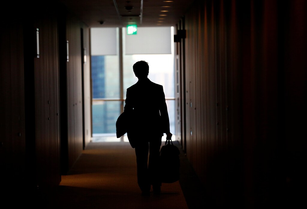 An IT engineer, who does not want to be identified, poses against a window after having an interview with Reuters in Tokyo, Japan, December 7, 2016. Picture taken on December 7, 2016. REUTERS/Kim Kyung-Hoon - RC114CAEE990