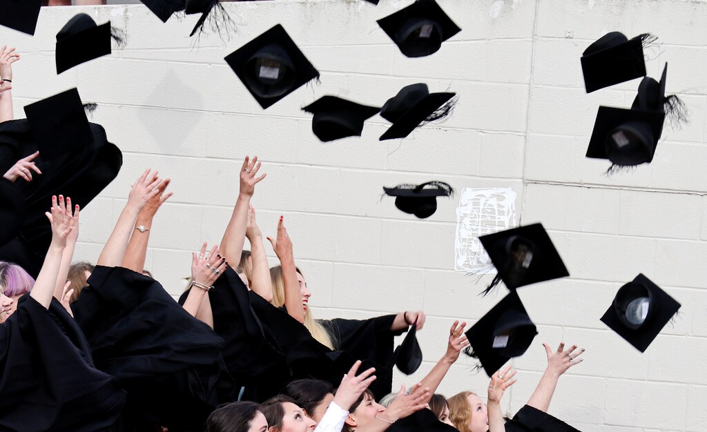 Warwick University graduates throw their graduation mortar boards into the air in celebration on the day of their graduation ceremony in Warwick, Britain July 17, 2017. Picture taken July 17, 2017. REUTERS/Russell Boyce - RTX3C37E