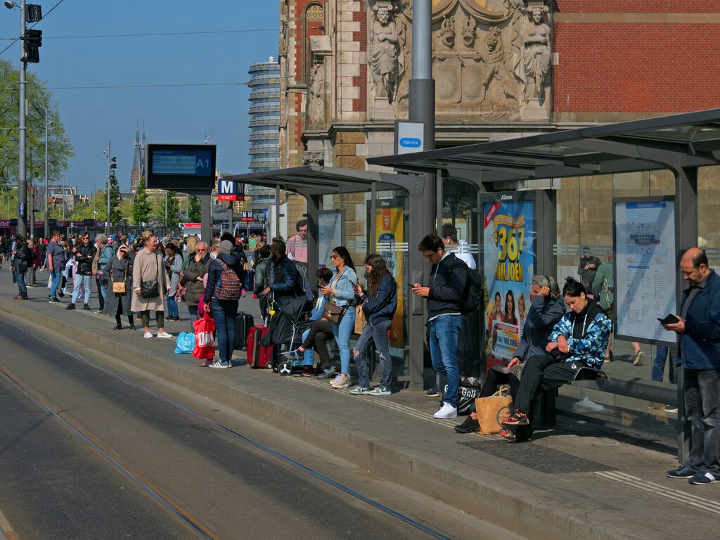 Un grupo de personas esperando en una parada de autobús en Ámsterdam, Países Bajos.