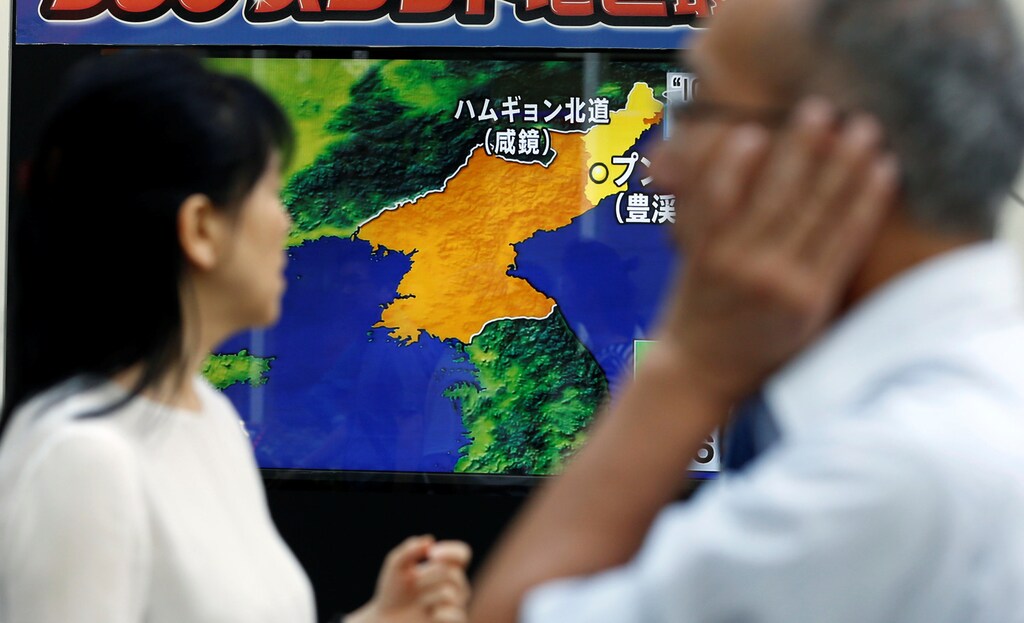 People walk past a street monitor showing a news report about North Korea's nuclear test, in Tokyo, Japan, September 3, 2017. REUTERS/Toru Hanai - RC117D87FCB0