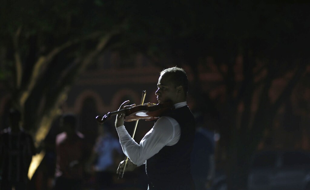 A man plays a violin for passersby during the 2014 World Cup, outside the Manaus Opera House June 16, 2014. In a project called 'On the Sidelines' Reuters photographers share pictures showing their own quirky and creative view of the 2014 World Cup in Brazil. REUTERS/Siphiwe Sibeko (BRAZIL - Tags: SPORT SOCCER WORLD CUP SOCIETY) - GM1EA6H0XLH01