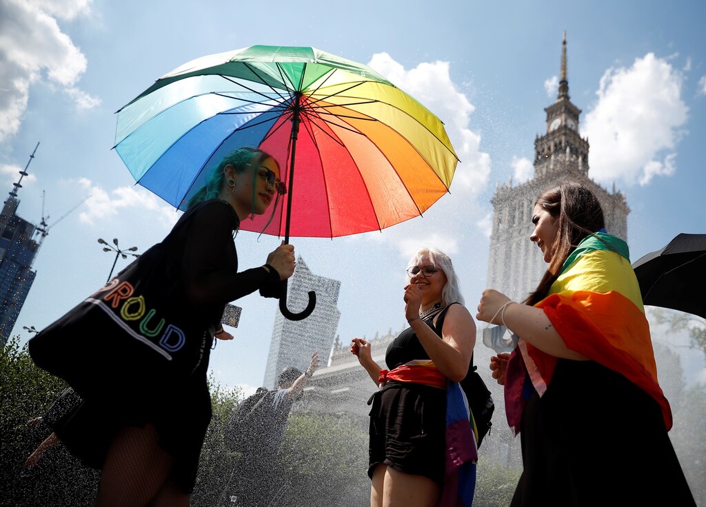 People gather for the "Equality Parade" rally in support of the LGBT community with multicoloured umbrellas, glasses and other accessories
