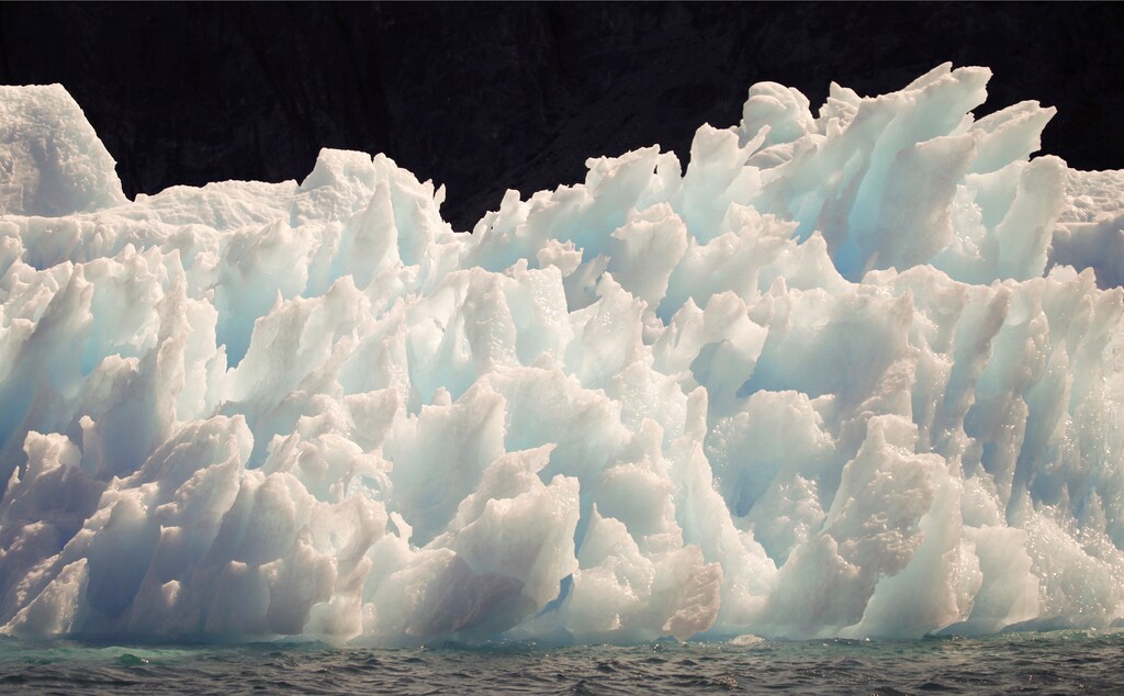 A large iceberg melts into jagged edges as it floats in Eriks Fjord near the town of Narsarsuaq in southern Greenland July 26, 2009. REUTERS/Bob Strong/File Photo - RTSL74X