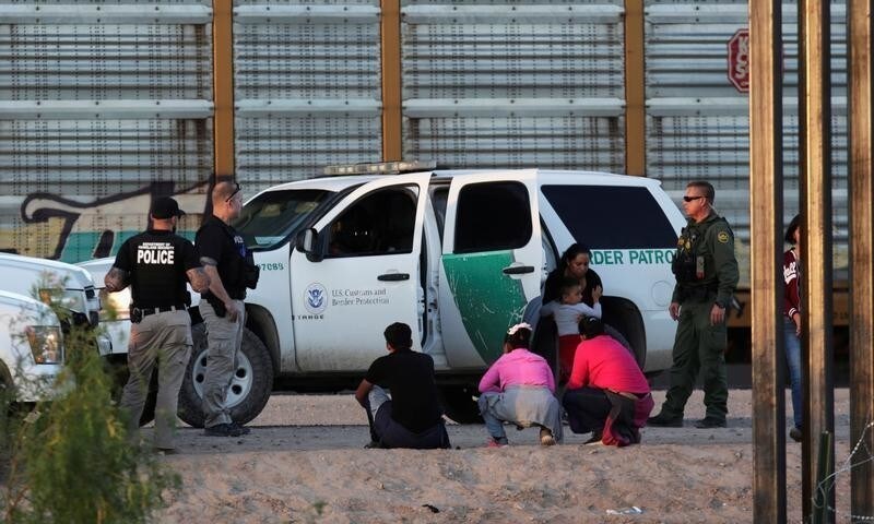 An immigrant family is detained by the U.S. Customs and Border Protection officials after crossing illegally into the United States and turning themselves in to request for asylum in El Paso, Texas, as seen from Ciudad Juarez, Mexico July 9, 2019. REUTERS/Daniel Becerril - RC199BA65F20