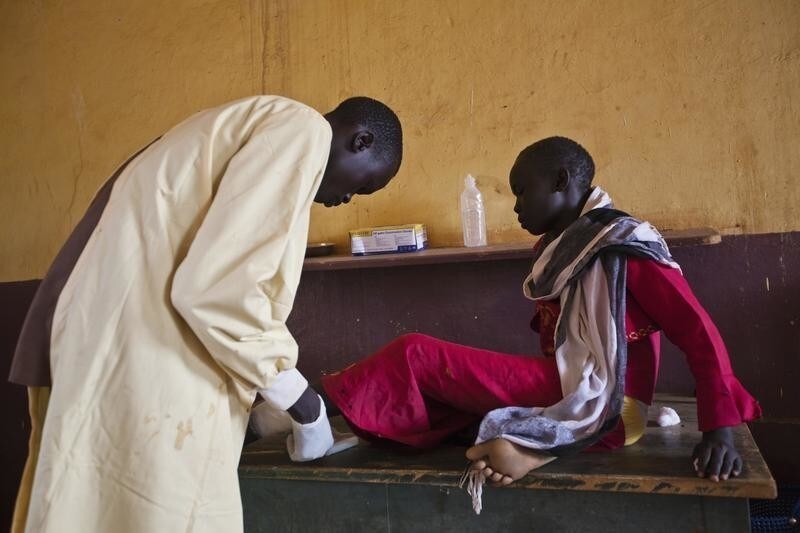 A girl is treated by a medic at the Aweil State Hospital in Aweil, the only hospital in the South Sudanese state of Northern Bahr el Ghazal, June 2, 2012. As in many developing nations, international aid is both an invaluable help to South Sudan and a crutch that sometimes enables it to avoid reality. Development experts have grown more sophisticated in recent decades about how they deliver aid. But in fragile states such as South Sudan, getting the balance right between helping a country and helping that country help itself remains incredibly difficult. Picture taken June 2, 2012. To match Special Report SOUTH-SUDAN/AID REUTERS/Adriane Ohanesian (SOUTH SUDAN - Tags: ANNIVERSARY HEALTH SOCIETY) - GM1E87A0K9L01