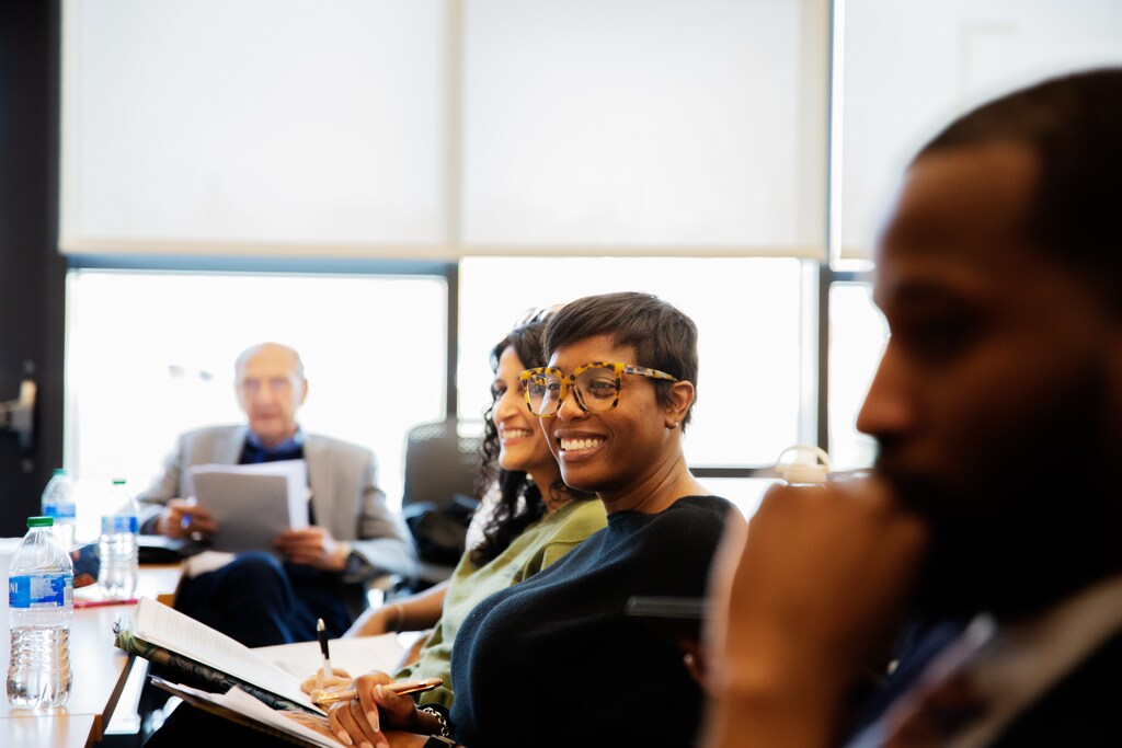 Group of men and women at a meeting, collective social innovation.