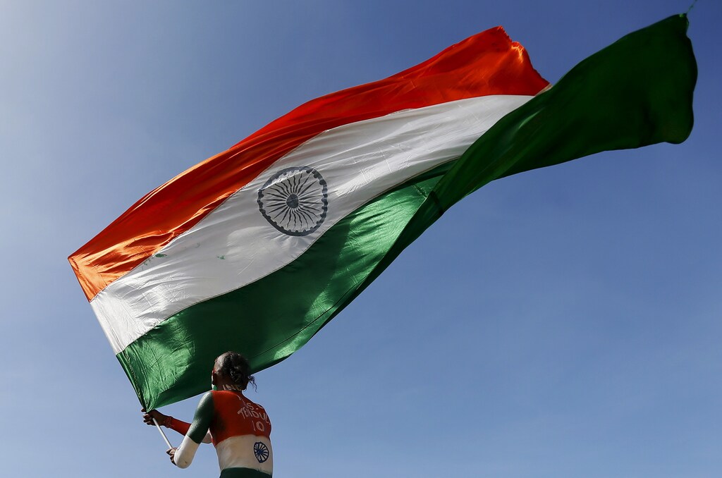 A supporter of the Indian cricket team waves the Indian national flag during the second day of the first test cricket match between India and Sri Lanka in Galle August 13, 2015. REUTERS/Dinuka Liyanawatte - RTX1O4UV