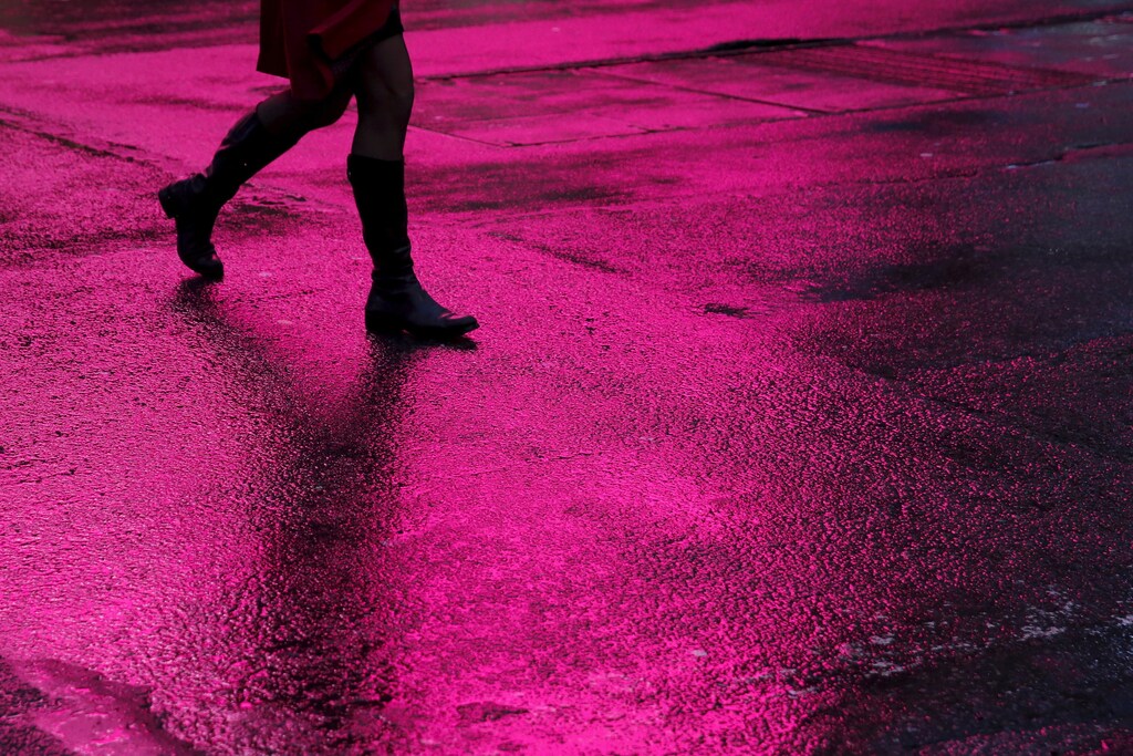 A woman walks in silhouette across a rain soaked 7th avenue in New York February 24, 2016. REUTERS/Shannon Stapleton - GF10000322098