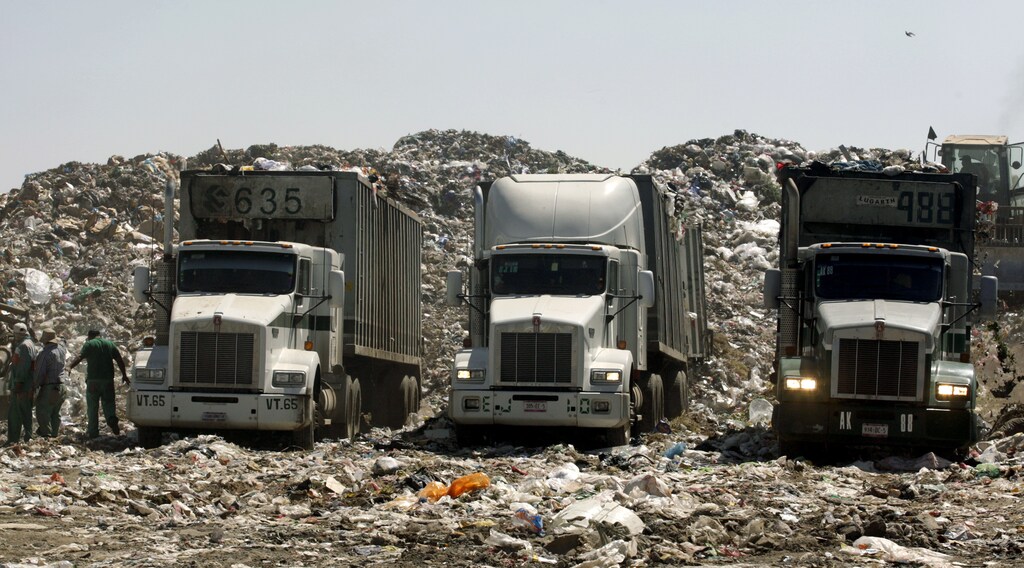 Trucks with garbage are parked at the Nezahualcoyotl dump site in Mexico City February 6, 2009. Mexico City is facing a crisis over where to put its trash -- enough to fill four sports stadiums a year -- with its sprawling dump already crammed to bursting and under a closure order. One of the world's biggest landfills, the Nezahualcoyotl dump site is a fifth the size of Manhattan and sits inside the urban sprawl of the fast-growing Mexican capital. Picture taken February 6, 2009. REUTERS/Daniel Aguilar (MEXICO) - GM1E52D07FA01