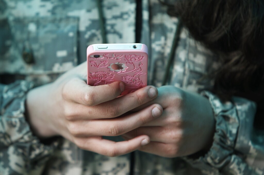 A student from the General Yermolov Cadet School plays with her mobile phone during a two-day field exercise near the village of Sengileyevskoye, just outside the south Russian city of Stavropol April 13, 2014. The General Yermolov Cadet School in the southern Russian city of Stavropol is a state-run institution that teaches military and patriotic classes in addition to a normal syllabus. The school allows its pupils to take part in field-training trips, during which they spend time at a base and undergo physical drills and weapons training. The outings are seen as a treat for students, and those with bad grades are not allowed to go. The school is named after the Russian imperial general Alexei Yermolov and many of its students are from military backgrounds. Picture taken April 13, 2014. REUTERS/Eduard Korniyenko (RUSSIA - Tags: MILITARY EDUCATION SOCIETY)ATTENTION EDITORS: PICTURE 06 OF 35 FOR PACKAGE 'WEAPONS TRAINING FOR RUSSIA'S CADETS'. TO FIND ALL IMAGES SEARCH 'YERMOLOV KORNIYENKO' - GM1EA4M0SRI01