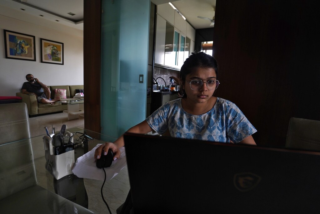Khushbu Hitesh Mehta, 22, an architecture student, works on her project as her father Hitesh Mehta, 47, a businessman, speaks on his mobile phone inside his three-room apartment in a high-rise building during a 21-day nationwide lockdown to slow the spreading of coronavirus disease (COVID-19), in Mumbai, India March 31, 2020. REUTERS/Hemanshi Kamani - RC20VF968OXN