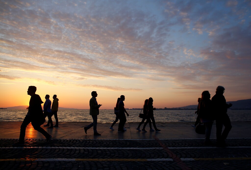 People walk along during sunset in the Aegean port city of Izmir, Turkey, April 15, 2017.
