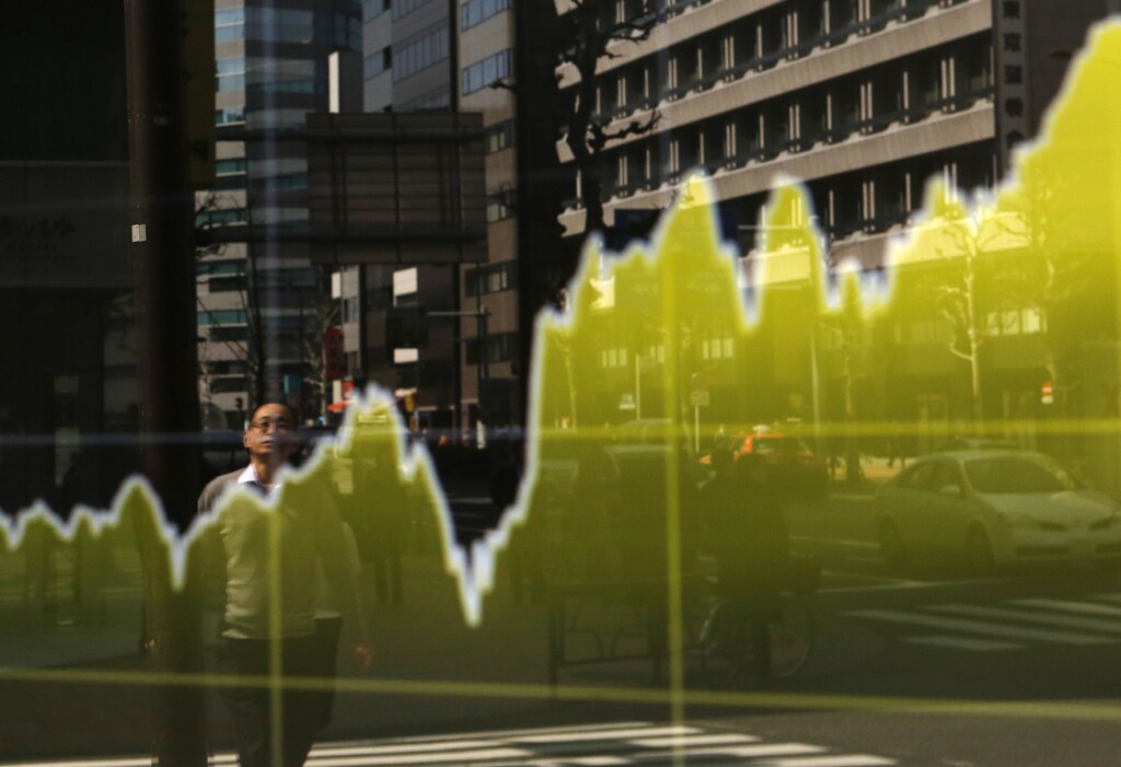 A pedestrian is reflected in an electronic board showing the graph of the recent fluctuations of Japan's Nikkei average outside a brokerage in Tokyo March 13, 2015. Japanese shares extended gains on Friday as industrial robot maker Fanuc jumped more than 10 percent on a report that it will consider raising its dividend and buying back stock. The Nikkei share average rose 1.3 percent to 19,242.17 points by late morning, a level last seen in 2000, while the broader Topix rose 0.9 percent to 1,560.52, a seven-year high. REUTERS/Yuya Shino (JAPAN - Tags: BUSINESS) - GM1EB3D0XTW01